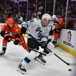 Dec 3, 2025; Anaheim, California, USA; Utah Mammoth defenseman Nate Schmidt (88) moves the puck ahead of Anaheim Ducks center Leo Carlsson (91) during the third period at Honda Center.