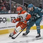 1er avril 2026 ; San Jose, Californie, États-Unis ; l'ailier droit des Ducks d'Anaheim, Troy Terry (19), et le défenseur des Sharks de San Jose, Vincent Desharnais (5), se disputent la rondelle durant la première période au SAP Center de San Jose.