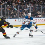 Jan 17, 2026; Vancouver, British Columbia, CAN; Vancouver Canucks forward David Kampf (64) stick checks Edmonton Oilers forward Connor McDavid (97) in the third period at Rogers Arena.