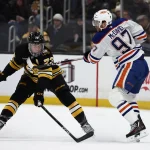 Dec 18, 2025; Boston, Massachusetts, USA; Boston Bruins defenseman Charlie McAvoy (73) breaks up a pass by Edmonton Oilers center Connor McDavid (97) during the first period at TD Garden.