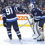 Oct 30, 2023; Winnipeg, Manitoba, CAN; Winnipeg Jets center Cole Perfetti (91) gives Winnipeg Jets goaltender Connor Hellebuyck (37) a stick tap before the start of a game against the New York Rangers at Canada Life Centre.