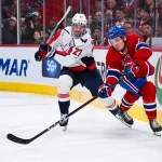 27 avril 2025; Montréal, Québec, Canada; Jake Evans (71), centre des Canadiens de Montréal, dégage la rondelle au but alors qu'Alex Alexeyev (27), défenseur des Capitals de Washington, le poursuit, durant la troisième période du quatrième match de la première ronde des séries éliminatoires de la Coupe Stanley 2025 au Centre Bell.