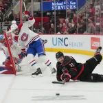29 mai 2026 ; Raleigh, Caroline du Nord, États-Unis ; l'ailier droit des Hurricanes de la Caroline, Andrei Svechnikov (37), joue la rondelle face au centre des Canadiens de Montréal, Kirby Dach (77), et au gardien de but Jakub Dobes (75), lors du cinquième match de la finale de l'Association de l'Est des séries éliminatoires de la Coupe Stanley 2026, durant la première période au Lenovo Center.