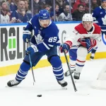 9 novembre 2024; Toronto, Ontario, Canada; L'ailier gauche des Maple Leafs de Toronto, Nicholas Robertson (89), dispute la rondelle au défenseur des Canadiens de Montréal, Kaiden Guhle (21), durant la troisième période à la Scotiabank Arena.