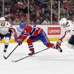 6 avril 2023; Montréal, Québec, Canada; L'attaquant des Canadiens de Montréal, Nick Suzuki (14), se faufile entre l'attaquant des Capitals de Washington, Anthony Mantha (39), et son coéquipier, le défenseur John Carlson (74), durant la deuxième période au Centre Bell.