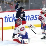 4 février 2026; Winnipeg, Manitoba, Canada; Cole Perfetti (91), centre des Jets de Winnipeg, célèbre un but de l'ailier gauche Kyle Connor (81) (non visible sur la photo) contre le gardien des Canadiens de Montréal, Samuel Montembeault (35), en première période au Canada Life Centre.