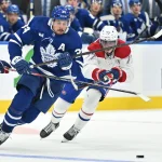 Oct 2, 2023; Toronto, Ontario, CAN; Toronto Maple Leafs forward Auston Matthews (34) carries the puck past Montreal Canadiens forward Kirby Dach (77) in the third period at Scotiabank Arena.