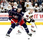 Nov 22, 2023; Columbus, Ohio, USA; Columbus Blue Jackets center Adam Fantilli (11) shoots the puck as Chicago Blackhawks center Connor Bedard (98) trails the play during the first period at Nationwide Arena.