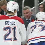 Nov 2, 2024; Pittsburgh, Pennsylvania, USA; Montreal Canadiens head coach Martin St. Louis (rear) talks to defenseman Kaiden Guhle (21) and center Kirby Dach (77) on the bench against the Pittsburgh Penguins during the third period at PPG Paints Arena