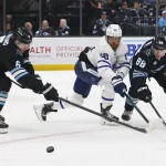 Jan 13, 2026; Salt Lake City, Utah, USA; Toronto Maple Leafs right wing William Nylander (88) battles for the puck with Utah Mammoth defenseman John Marino (6) and defenseman Nate Schmidt (88) during the first period at Delta Center.