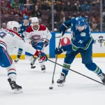 11 mars 2025 ; Vancouver (Colombie-Britannique, Canada) ; le défenseur des Canadiens de Montréal, Mike Matheson (8), charge avec son bâton l\'attaquant des Canucks de Vancouver, Jake DeBrusk (74), en deuxième période au Rogers Arena.