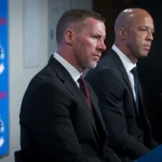 Jun 4, 2026; Vancouver, BC, CANADA; General manager Ryan Johnson and Manny Malhotra listen to a question from the media during a press conference where the Vancouver Canucks introduce Malhotra as their new head coach during a press conference at Rogers Arena.