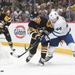 Nov 25, 2023; Pittsburgh, Pennsylvania, USA; Pittsburgh Penguins defenseman Erik Karlsson (65) and Toronto Maple Leafs defenseman Morgan Rielly (44) go for the puck during the second period at PPG Paints Arena.