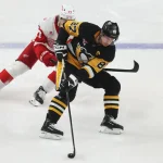 Mar 31, 2026; Pittsburgh, Pennsylvania, USA; Pittsburgh Penguins center Sidney Crosby (87) handles the puck against Detroit Red Wings defenseman Simon Edvinsson (77) during the third period at PPG Paints Arena.