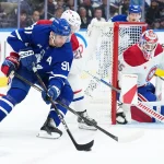 8 octobre 2025; Toronto, Ontario, Canada; John Tavares (91), centre des Maple Leafs de Toronto, se dispute la rondelle avec Kaiden Guhle (21), défenseur des Canadiens de Montréal, durant la première période à la Scotiabank Arena.