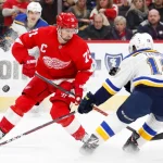 Nov 28, 2018; Detroit, MI, USA; Detroit Red Wings center Dylan Larkin (71) and St. Louis Blues center Robert Thomas (18) fight for the puck during the second period at Little Caesars Arena.