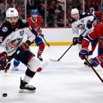 Mar 26, 2026; Montreal, Quebec, CAN; Columbus Blue Jackets forward Kirill Marchenko (86) plays the puck and Montreal Canadiens defenseman Kaiden Guhle (21) defends during the third period at the Bell Centre.