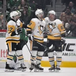 Dec 7, 2025; Dallas, Texas, USA; Pittsburgh Penguins center Tommy Novak (18) and center Sidney Crosby (87) and right wing Bryan Rust (17) celebrates a goal scored by Novak against the Dallas Stars during the second period at American Airlines Center.