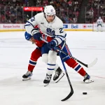 30 septembre 2023; Montréal, Québec, Canada; L'ailier gauche des Maple Leafs de Toronto, Matthew Knies (23), joue la rondelle contre le défenseur des Canadiens de Montréal, David Reinbacher (64), durant la troisième période au Centre Bell.