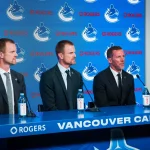 May 14, 2026; Vancouver, BC, Canada; Henrik Sedin and Daniel Sedin listen to Ryan Johnson speak during a press conference where the Vancouver Canucks name new senior management staff. Henrik Sedin and his twin brother Daniel Sedin have been appointed as co-presidents of hockey operations and Ryan Johnson is now the new general manager of the club at Rogers Arena.