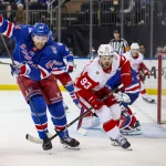 Apr 4, 2026; New York, New York, USA; New York Rangers defenseman Vladislav Gavrikov (44) and Detroit Red Wings right wing Alex DeBrincat (93) skate for the puck during the first period at Madison Square Garden. :