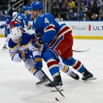 Apr 8, 2026; New York, New York, USA; New York Rangers defenseman Braden Schneider (4) checks Buffalo Sabres left wing Zach Benson (6) during the first period at Madison Square Garden.