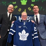May 4, 2026; Toronto, Ontario, CANADA; Maple Leaf Sports and Entertainment CEO Keith Pelley holds a team jersey between Toronto Maple Leafs general manager John Chayka (right) and senior executive advisor Mats Sundin during an introductory news conference at Real Sports Bar and Grill.