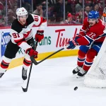 5 avril 2026; Montréal, Québec, Canada; Dawson Mercer (91), centre des Devils du New Jersey, joue la rondelle face à Arber Xhekaj (72), défenseur des Canadiens de Montréal, durant la deuxième période au Centre Bell.