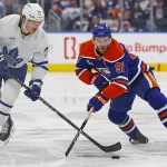 Feb 3, 2026; Edmonton, Alberta, CAN; Toronto Maple Leafs forward Bobby McMann (74) and Edmonton Oilers forward Connor McDavid (97) battle for a loose puck during the third period at Rogers Place.