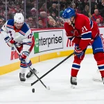 19 janvier 2025; Montréal, Québec, Canada; L'ailier gauche des Rangers de New York, Alexis Lafrenière (13), joue la rondelle contre le défenseur des Canadiens de Montréal, Kaiden Guhle (21), durant la première période au Centre Bell.