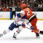Apr 24, 2026; Anaheim, California, USA; Edmonton Oilers center Connor McDavid (97) fights for the puck against Anaheim Ducks defenseman Jackson LaCombe (2) during the third period of game three of the first round of the 2026 Stanley Cup Playoffs at Honda Center.