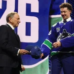 Jun 26, 2026; Buffalo, New York, USA; Caleb Malhotra reacts with NHL commissioner Gary Bettman after being selected with the third pick in the first round of the 2026 NHL Draft by the Vancouver Canucks at KeyBank Center.