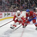 8 avril 2025; Montréal, Québec, Canada; l'attaquant des Red Wings de Detroit, Dylan Larkin (71), contrôle la rondelle tandis que l'attaquant des Canadiens de Montréal, Josh Anderson (17), effectue un échec-avant durant la deuxième période au Centre Bell.