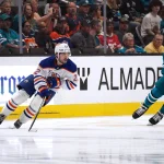 Apr 8, 2026; San Jose, California, USA; Edmonton Oilers center Matthew Savoie (22) controls the puck against San Jose Sharks defenseman Mario Ferraro (38) during the second period at SAP Center at San Jose.