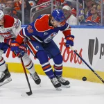 23 octobre 2025; Edmonton (Alberta, Canada); Noah Philp (48), attaquant des Oilers d'Edmonton, et Juraj Slafkovsky (20), attaquant des Canadiens de Montréal, se disputent une rondelle libre le long de la bande durant la deuxième période au Rogers Place.