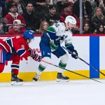 Jan 12, 2026; Montreal, Quebec, CAN; Vancouver Canucks center Elias Pettersson (40) plays the puck against Montreal Canadiens center Oliver Kapanen (91) during the third period at Bell Centre.