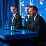 May 14, 2026; Vancouver, BC, Canada; Henrik Sedin and Daniel Sedin listen to Ryan Johnson speak during a press conference where the Vancouver Canucks name new senior management staff. Henrik Sedin and his twin brother Daniel Sedin have been appointed as co-presidents of hockey operations and Ryan Johnson is now the new general manager of the club at Rogers Arena.