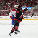 29 mai 2026 ; Raleigh, Caroline du Nord, États-Unis ; Logan Stankoven (22), centre des Hurricanes de la Caroline, exulte après avoir marqué un but à égalité numérique contre Phillip Danault (24), centre des Canadiens de Montréal, et le gardien Jakub Dobes (non visible sur la photo), lors du cinquième match de la finale de l'Association de l'Est des séries éliminatoires de la Coupe Stanley 2026, durant la première période au Lenovo Center.