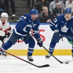 Feb 28, 2026; Toronto, Ontario, CAN; Toronto Maple Leafs forward Auston Matthews (34) passes the puck away from Ottawa Senators forward Lars Eller (89) as forward Matthew Knies (23) looks on in the first period at Scotiabank Arena. :