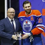 Jan 10, 2026; Edmonton, Alberta, CAN; Edmonton Oilers GM Stan Bowman presents Leon Draisaitl with a Tiffany Crystal for recording 1000 points in the NHL at Rogers Place.
