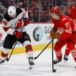 Apr 11, 2026; Detroit, Michigan, USA; New Jersey Devils left wing Brian Halonen (48) skates with the puck defended by Detroit Red Wings center Andrew Copp (18) and defenseman Simon Edvinsson (77) in the third period at Little Caesars Arena.