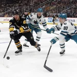 Mar 14, 2024; Pittsburgh, Pennsylvania, USA; Pittsburgh Penguins right wing Rickard Rakell (67) carries the puck into the offensive zone as San Jose Sharks center Mikael Granlund (64) and defenseman Calen Addison (33) defend during the first period at PPG Paints Arena. Mandatory Credit: Charles LeClaire-USA TODAY Sports