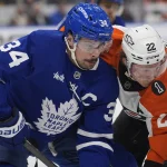 Mar 2, 2026; Toronto, Ontario, CAN; Toronto Maple Leafs forward Auston Matthews (34) and Philadelphia Flyers forward Christian Dvorak (22) battle for position after a face off during the second period at Scotiabank Arena. :