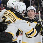 24 avril 2022 ; Montréal, Québec, Canada ; L'attaquant des Bruins de Boston, Patrice Bergeron (37 ans), célèbre avec ses coéquipiers, dont les attaquants Brad Marchand (63 ans) et Jake DeBrusk (74 ans), après avoir marqué un but contre les Canadiens de Montréal en première période au Centre Bell.