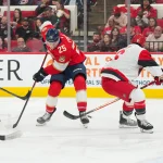 Sep 24, 2025; Raleigh, North Carolina, USA; Carolina Hurricanes defenseman Mike Reilly (6) pokes the puck away from Florida Panthers left wing Nolan Foote (25) during the second period at Lenovo Center.
