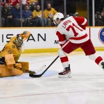 Mar 2, 2026; Nashville, Tennessee, USA; Nashville Predators goaltender Juuse Saros (74) blocks the shot of Detroit Red Wings center Dylan Larkin (71) during the third period at Bridgestone Arena.
