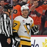 Apr 22, 2026; Philadelphia, Pennsylvania, USA; Pittsburgh Penguins center Sidney Crosby (87) is escorted to the penalty box by linesman Jonny Murray (95) against the Philadelphia Flyers during the second period in game three of the first round of the 2026 Stanley Cup Playoffs at Xfinity Mobile Arena.