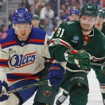 Jan 31, 2026; Edmonton, Alberta, CAN; Edmonton Oilers forward Curtis Lazar (20) and Minnesota Wild forward Vladimir Tarasenko (91) battle for a loose puck during the second period at Rogers Place.