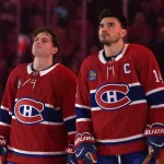 Apr 7, 2026; Montreal, Quebec, CAN; Montreal Canadiens forward Cole Caufield (13) and teammate forward Nick Suzuki (14) during the National Anthem before the game against the Florida Panthers at the Bell Centre.