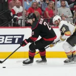 Jun 11, 2026; Raleigh, North Carolina, USA; Carolina Hurricanes defenseman Alexander Nikishin (21) carries the puck against Vegas Golden Knights center Nic Dowd (26) during the second period in game five of the 2026 Stanley Cup Final at Lenovo Center.